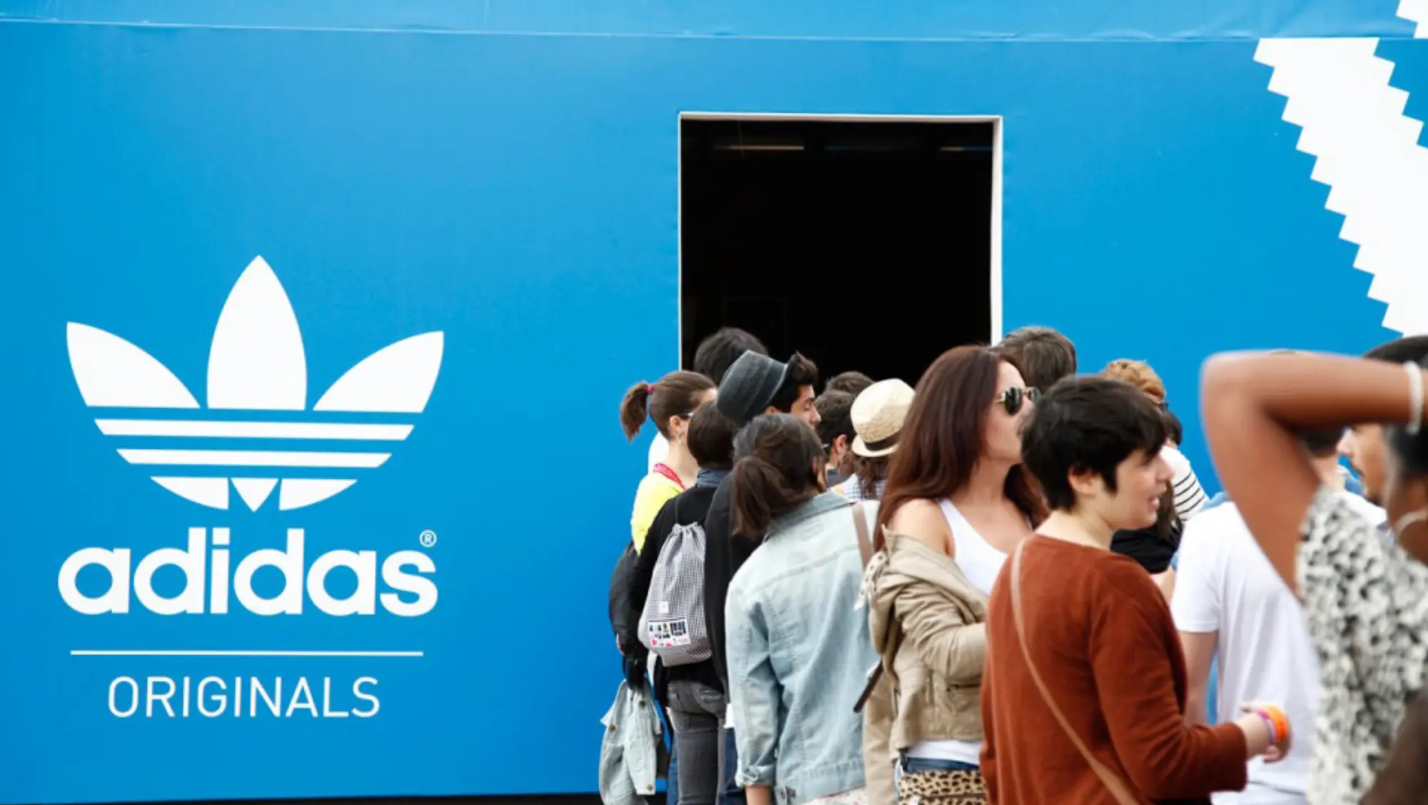 Festival visitors queuing at the entrance of the Adidas Originals pavilion