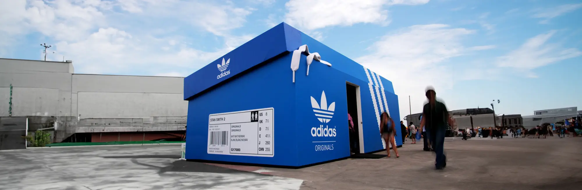 Blue shoebox-shaped Adidas Originals pavilion at a festival site