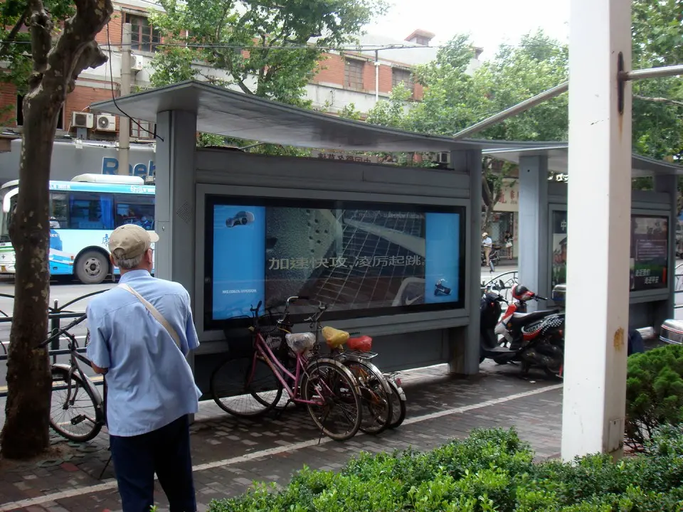 Passerby standing next to the Nike bus shelter while the screen shows an animation