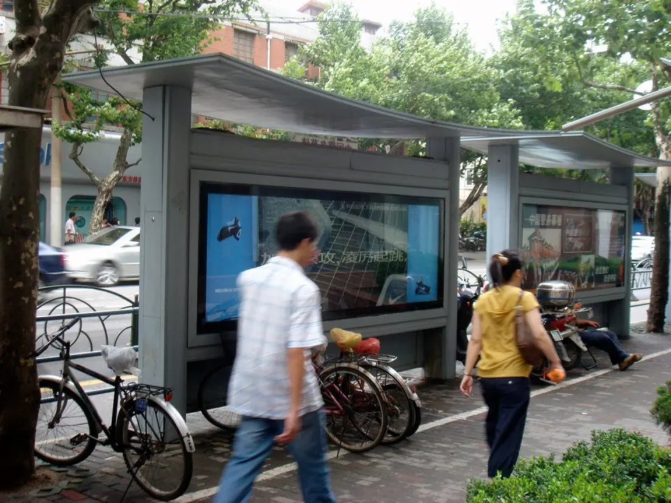 Two pedestrians walking past the Nike interactive bus shelter