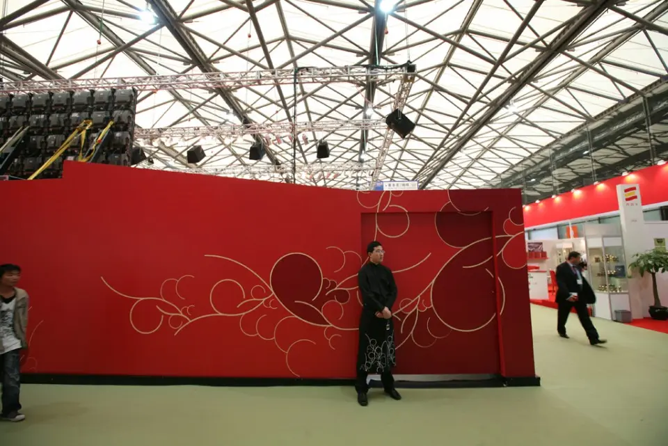 Red wall with white floral line decoration inside the trade fair hall