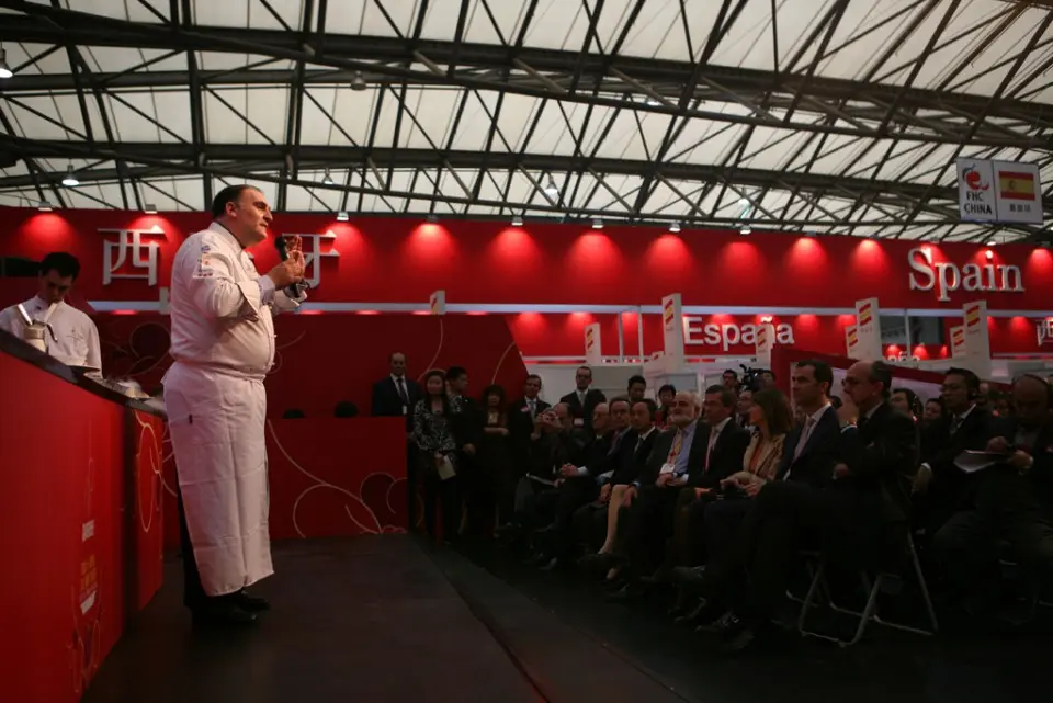 Chef speaking to an audience in the red Spanish showroom