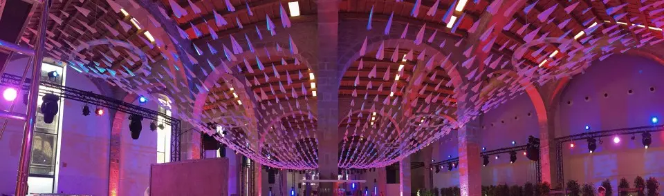 Long rows of paper planes hanging in lines under the arches of the hall