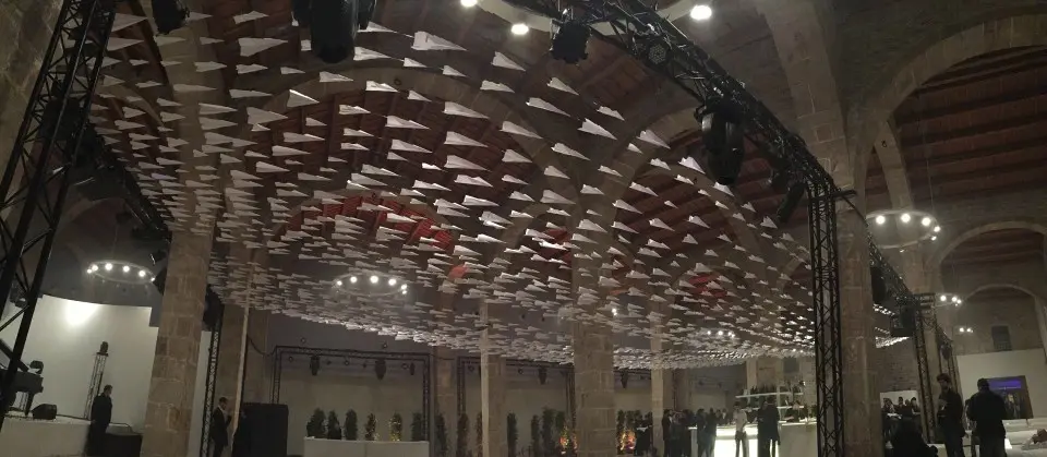 Wide view of the empty hall with the ceiling covered in paper planes